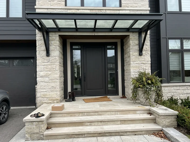 Blackened steel and glass entry canopy with limestone steps