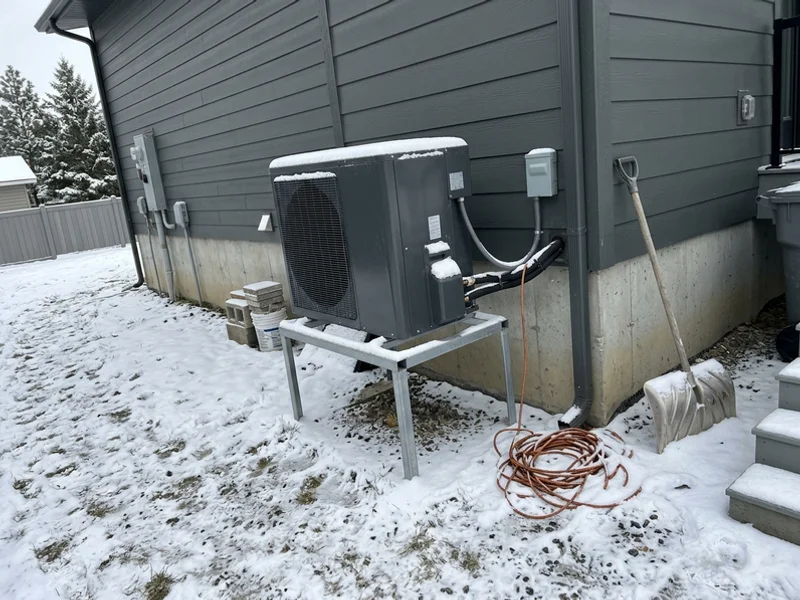 Cold-climate heat pump outdoor unit in light snow