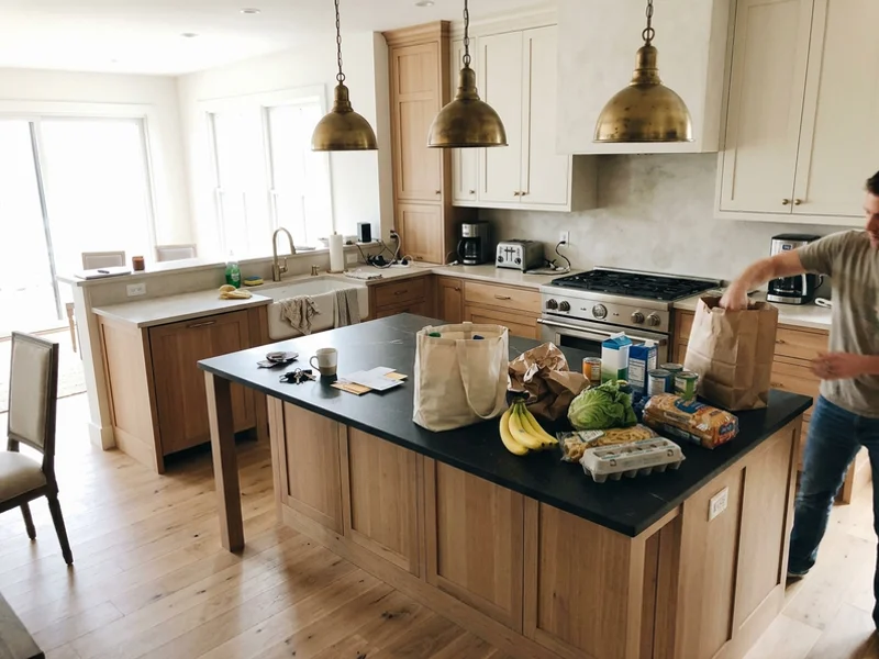 Kitchen with white oak floors and brass pendants in a new custom home
