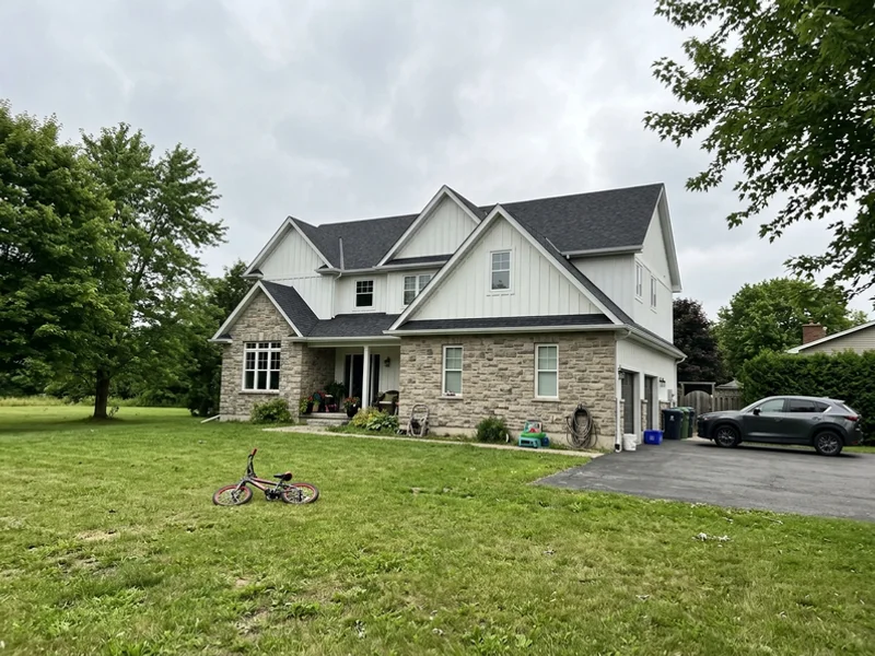 Transitional custom home with stone and board-and-batten on a large Headon Forest lot