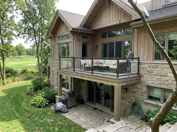 After: luxury stone custom home with walkout terrace facing the golf course in Millcroft at dusk