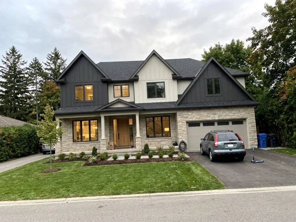 After: transitional stone and board-and-batten custom home in Headon Forest at dusk